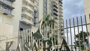 Une enseigne indiquant « KISARA Urban Resort Residences », avec un bâtiment moderne en arrière-plan.