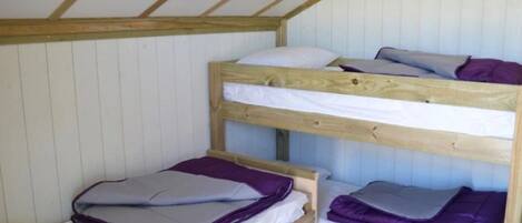 A bunk bed room with wooden beams and white walls.