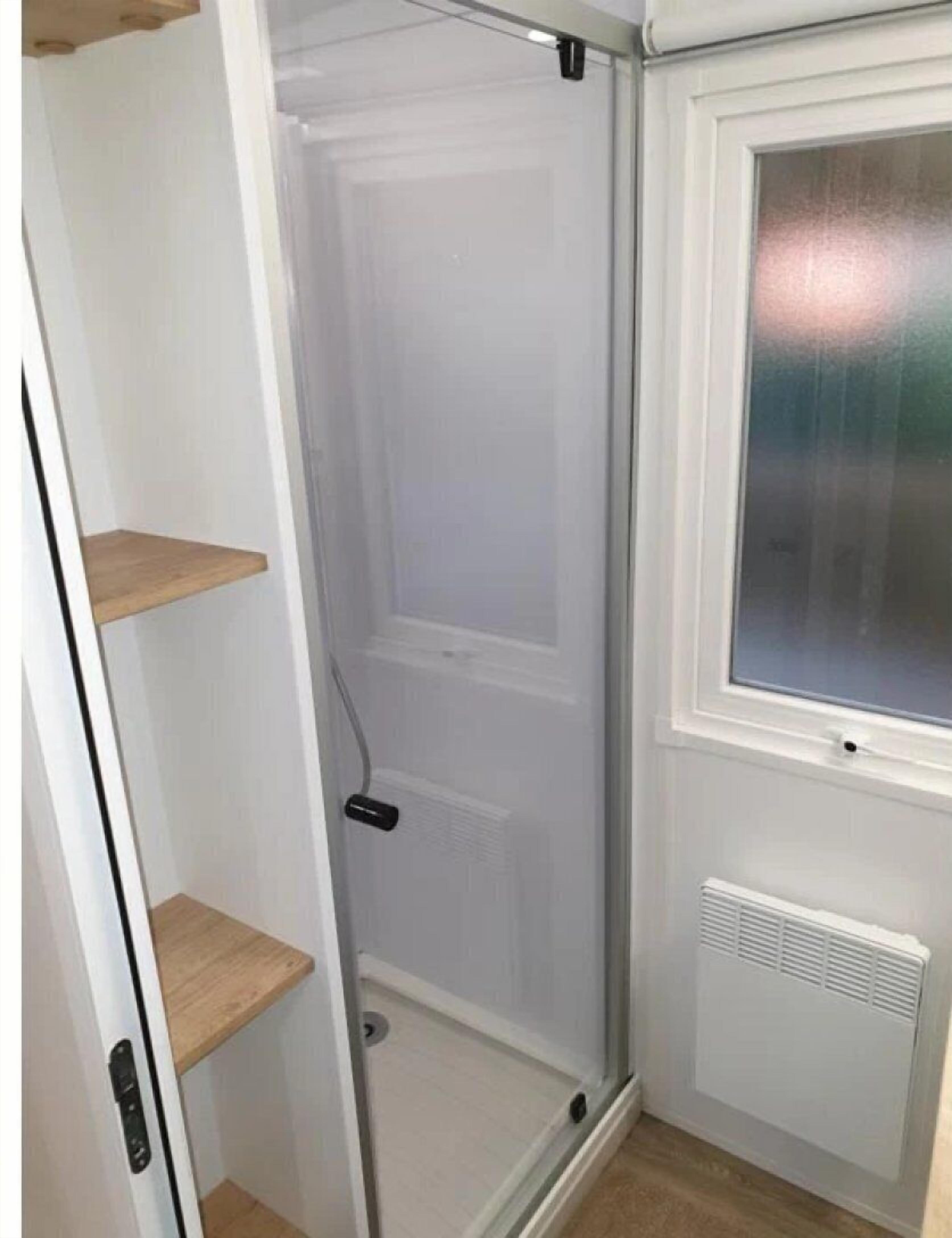 A small, enclosed room with a door, a window, and a radiator.