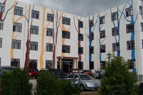 Un edificio de varios pisos con un diseño arquitectónico moderno, caracterizado por líneas verticales y ventanas rectangulares.