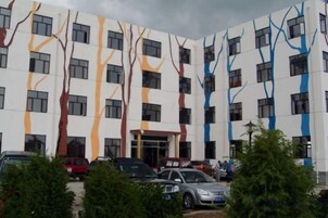 Un edificio de varios pisos con un diseño arquitectónico moderno, caracterizado por líneas verticales y ventanas rectangulares.
