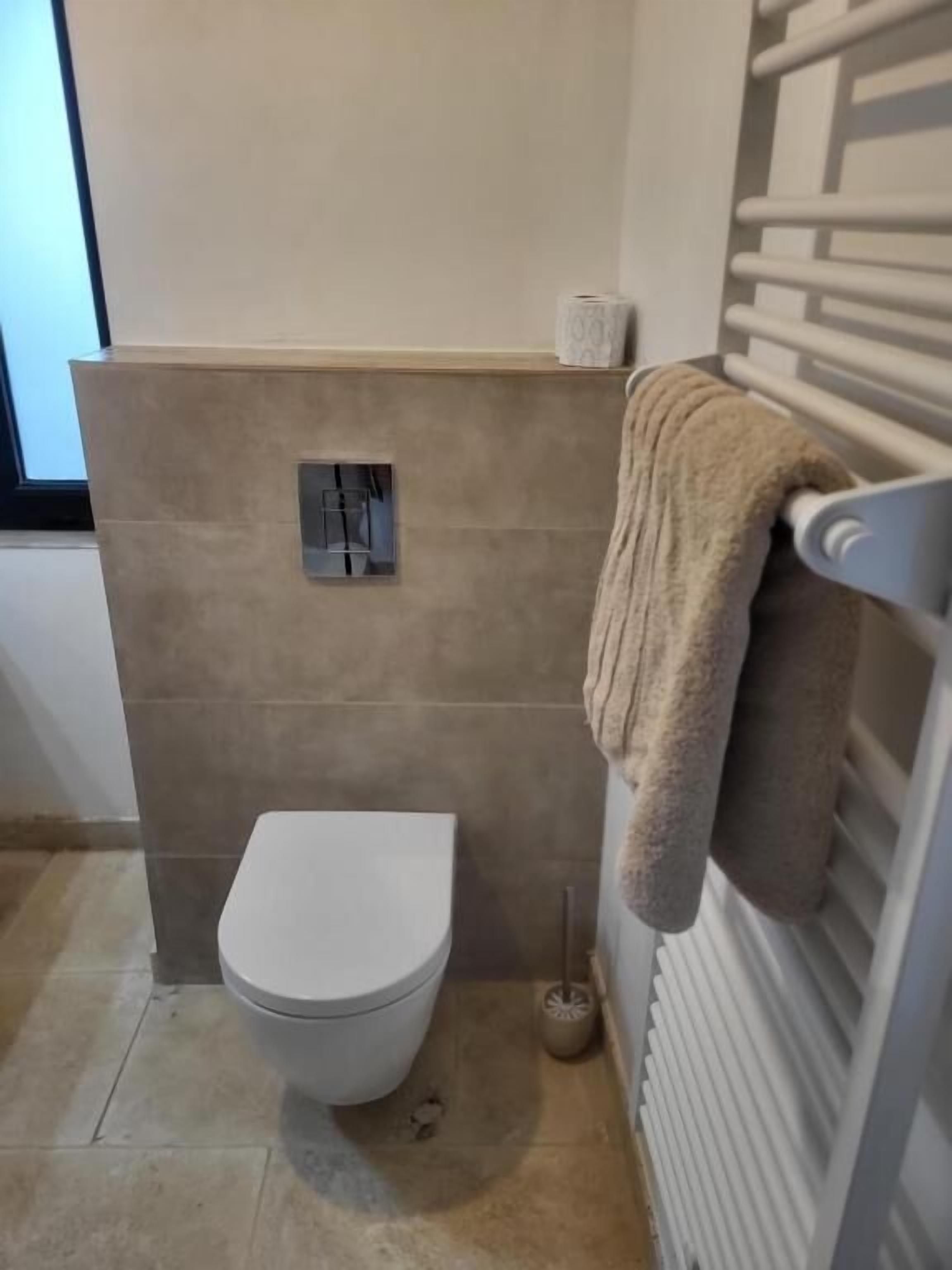 Un baño con inodoro, toallero y radiador.