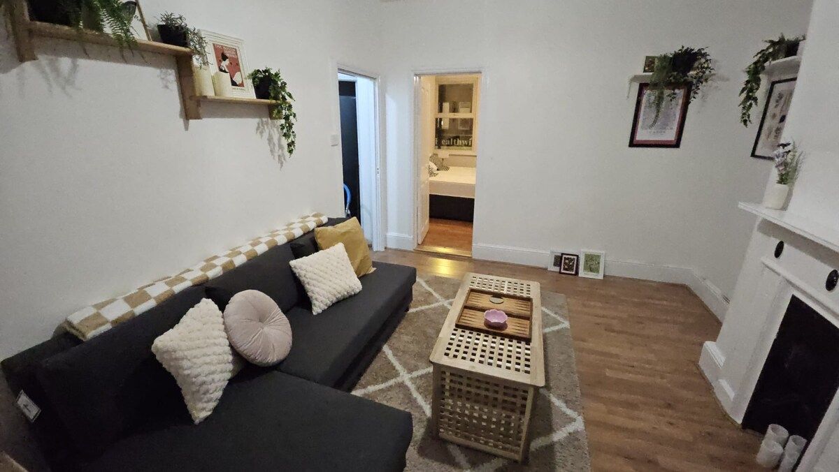A living room with a sofa, a coffee table, and a fireplace.