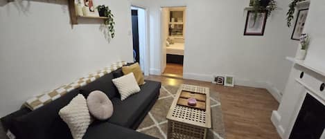 A living room with a sofa, a coffee table, and a fireplace.