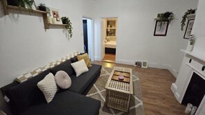 A living room with a sofa, a coffee table, and a fireplace. - Central Angel Location: 1BR Apartment (Greater London)