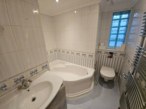 A bathroom with a bathtub, toilet, and sink.