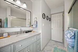 Chuveiro, secador de cabelo, toalhas de banho, papel higiênico