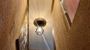 A narrow hallway with textured walls and two ceiling lights. - Hotel Naciuonal (Sobral)