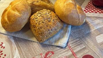 A basket of bread on a cloth with heart-shaped decorations.