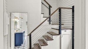 A staircase with wooden steps and metal railings leading to a white door.