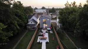 A residential backyard with a patio, seating area, and a pathway leading to the house. - Hot Tub - Mins to Short North - Retro Game Room - New Construction (Columbus)