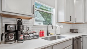 A modern kitchen with a coffee maker, toaster, and dish soap on the counter. - Hot Tub - Mins to Short North - Retro Game Room - New Construction (Columbus)