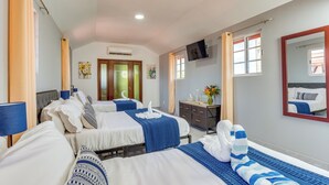 Een hotelkamer met twee bedden, een televisie, een dressoir en een spiegel.