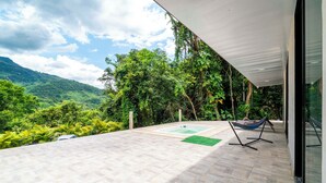 Un patio con vistas a exuberante vegetación y montañas.