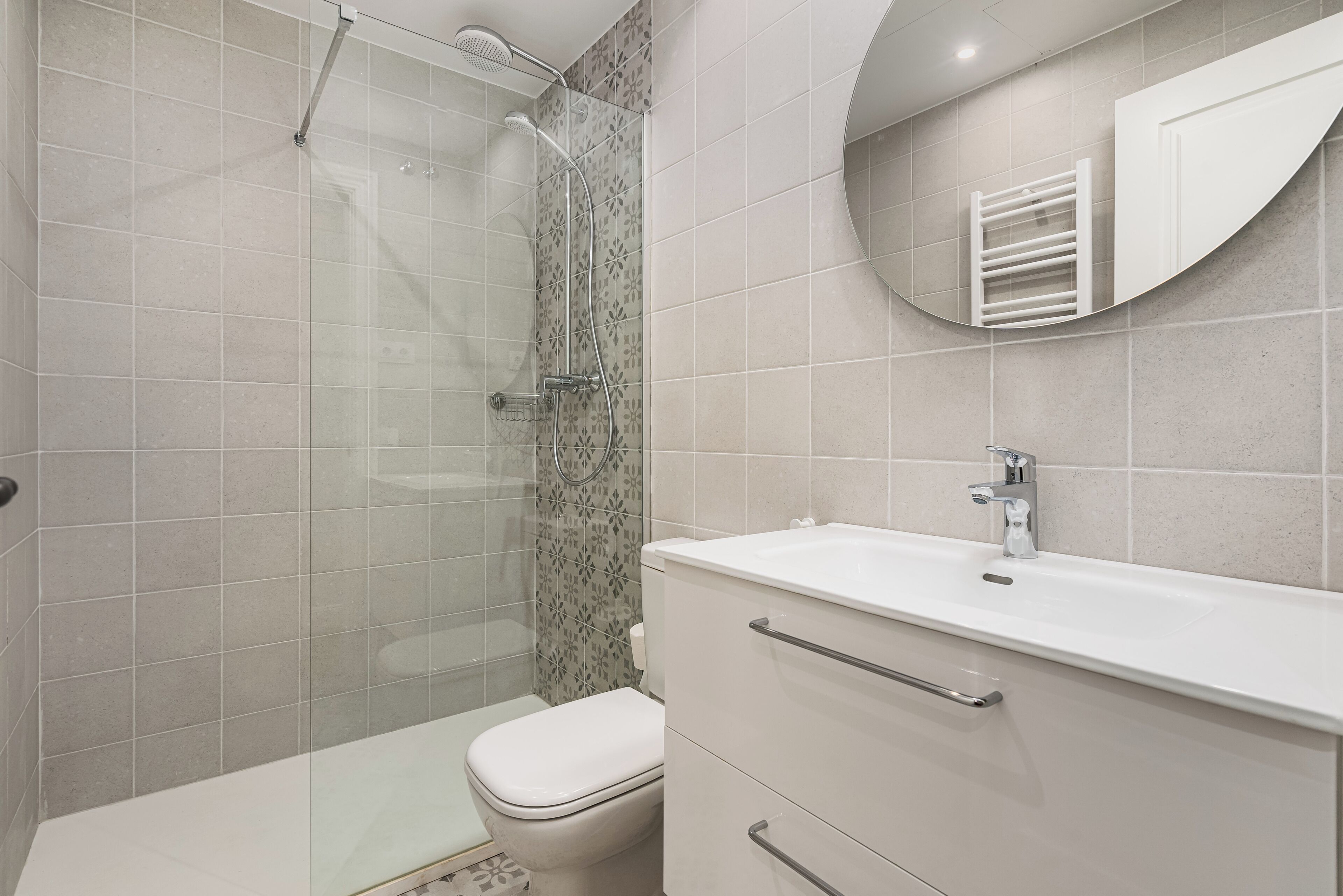 Une salle de bain moderne équipée d’une douche, de toilettes et d’un meuble-lavabo.