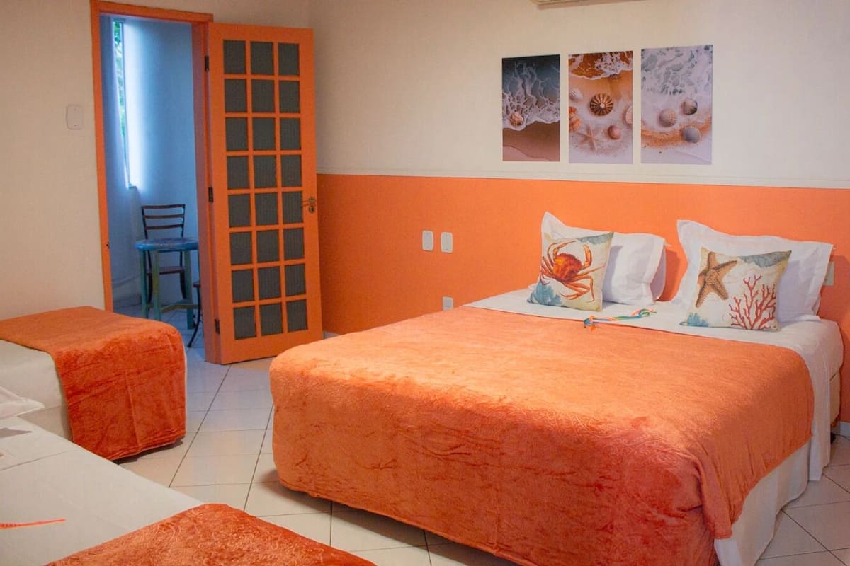 Um quarto com uma cama, uma cadeira e uma mesinha.