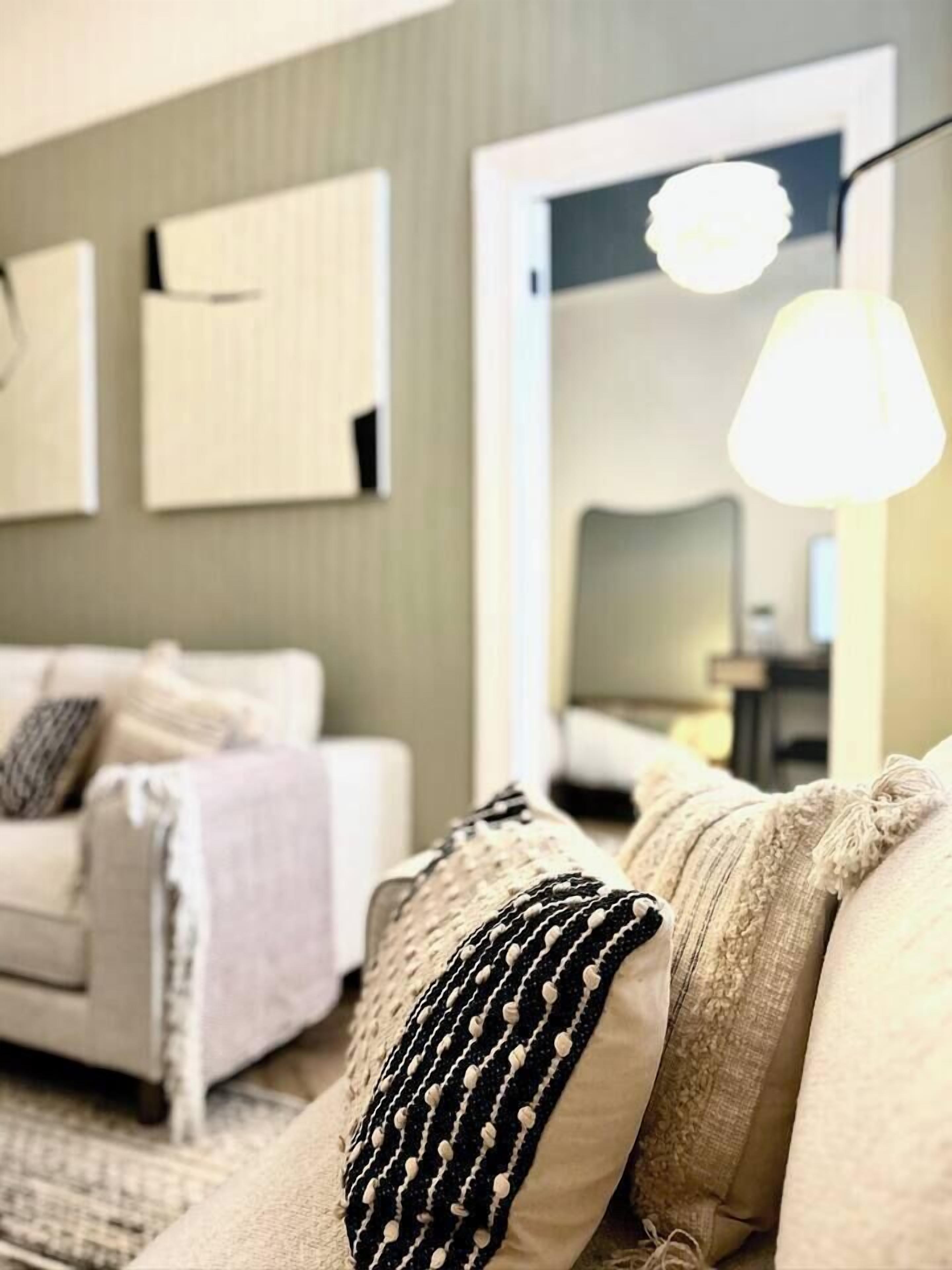 A cozy living room with a sofa, a coffee table, and a lamp.