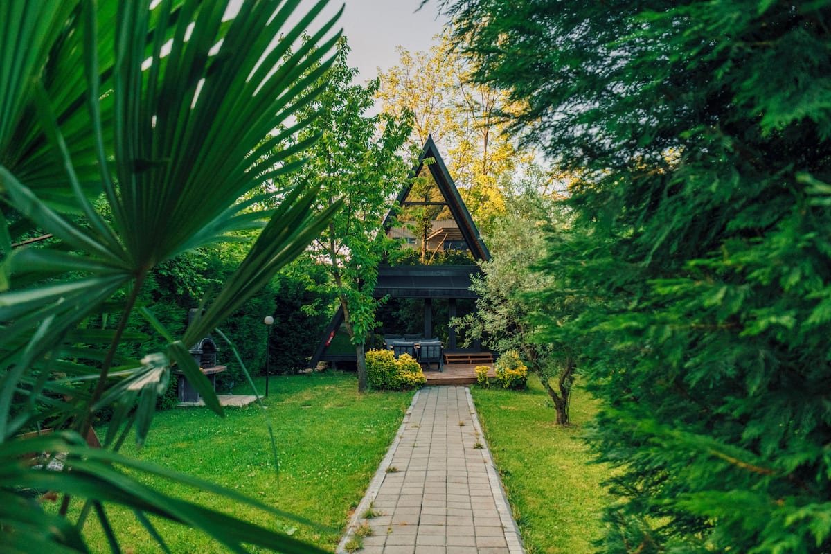 A pathway leading to a gazebo in a lush garden setting.