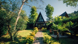 A triangular glass structure surrounded by lush greenery and a paved pathway leading to it. - MC Sapanca Hotel (Sapanca)