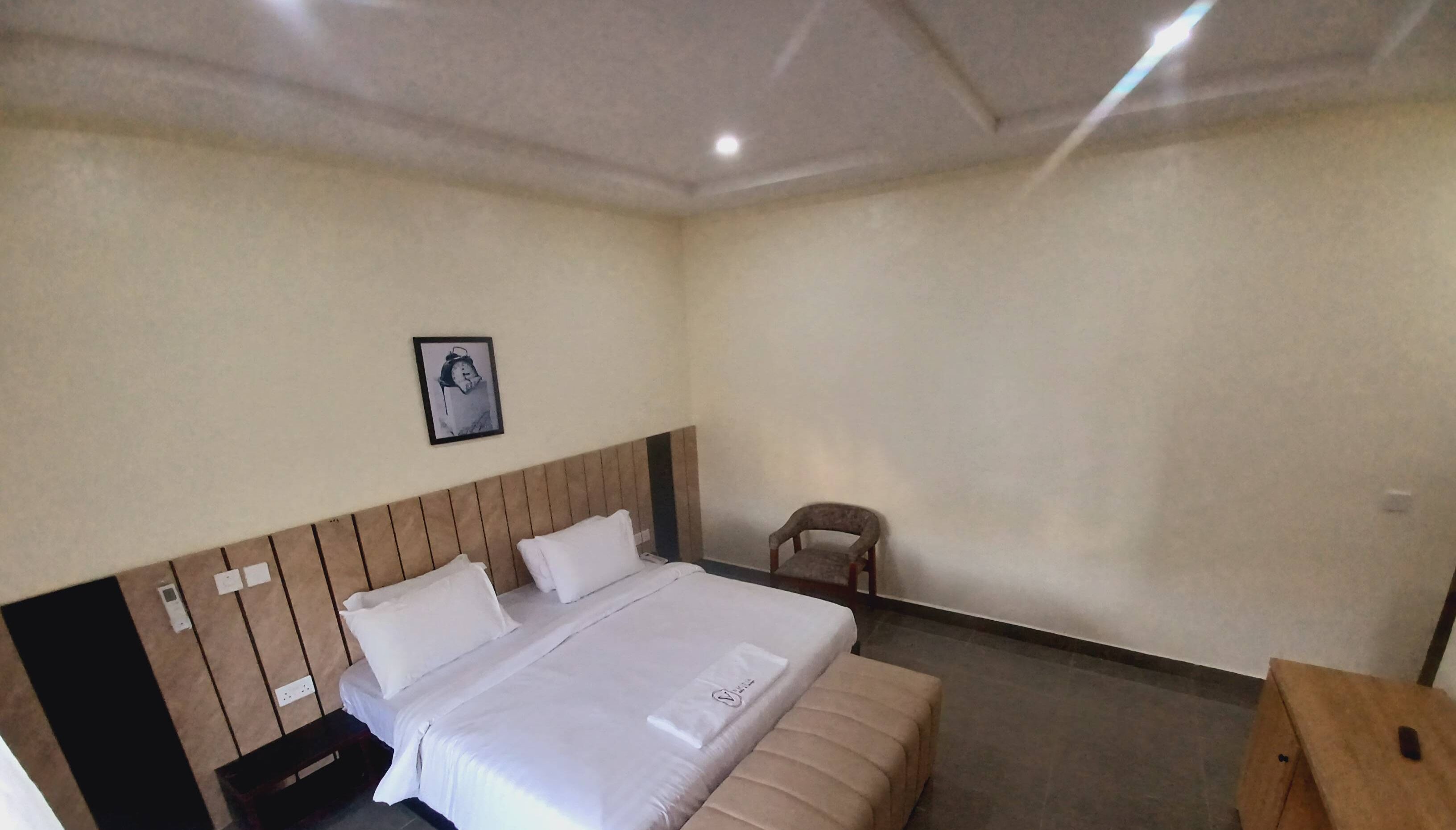 Una camera d'albergo con un letto, una sedia e un tavolino.