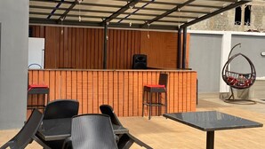 An outdoor seating area with a bar, two tables, and chairs. - Victia Suite and Lounge (Ijebu Ode)