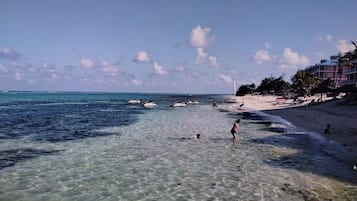 On the beach, white sand, sun-loungers, beach umbrellas