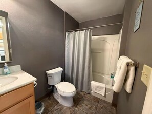 A bathroom with a toilet, sink, and shower. - Great North Lodging (Anchorage)