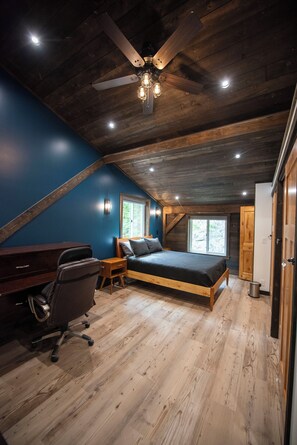 A bedroom with a sloped ceiling, a bed, a desk, and a chair. - Oz Lodge: Alice Chalet -Brand new, Alaskan chic chalet! (Seward)