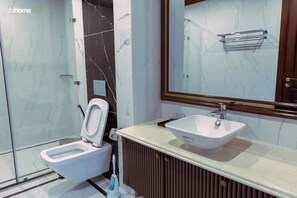 A modern bathroom with a toilet, bidet, and sink. - Siêu Biệt Thự Vinhome Bason - Trung tâm thành phố (Hồ Chí Minh)