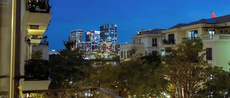 A balcony with a railing, a cityscape in the background, and a clear sky.