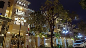 Un hotel de varios pisos con balcones ornamentados y una entrada con portón.
