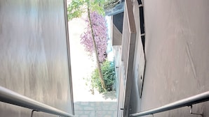 A staircase with metal handrails leading to an outdoor area with greenery. - OYO Hotel Tbs (Manacapuru)