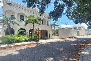 A building with a white facade, arched windows, and a gated entrance. - Hotel Rolovi Cancun (Cancun)