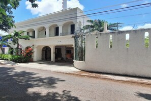A building with a white facade, multiple arches, and a gated entrance. - Hotel Rolovi Cancun (Cancun)
