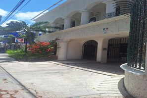 A building with a white facade, multiple arches, and a gated entrance. - Hotel Rolovi Cancun (Cancun)