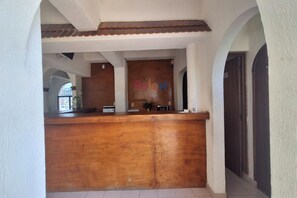 A reception desk with a wooden counter and a sign that reads 'Rovii'. - Hotel Rolovi Cancun (Cancun)