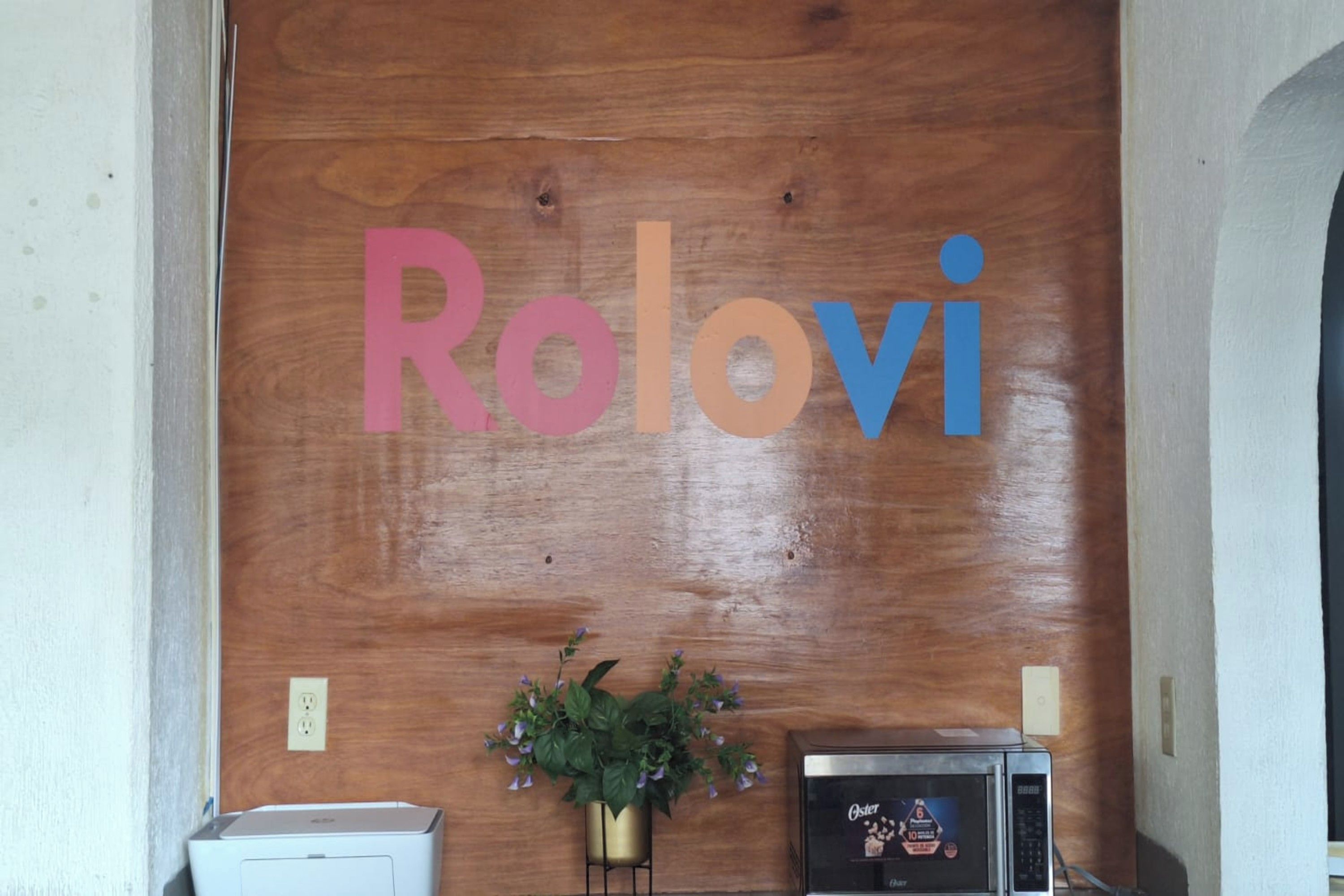 Una recepción con un fondo de madera que muestra el nombre 'Rolovi' en letras grandes.