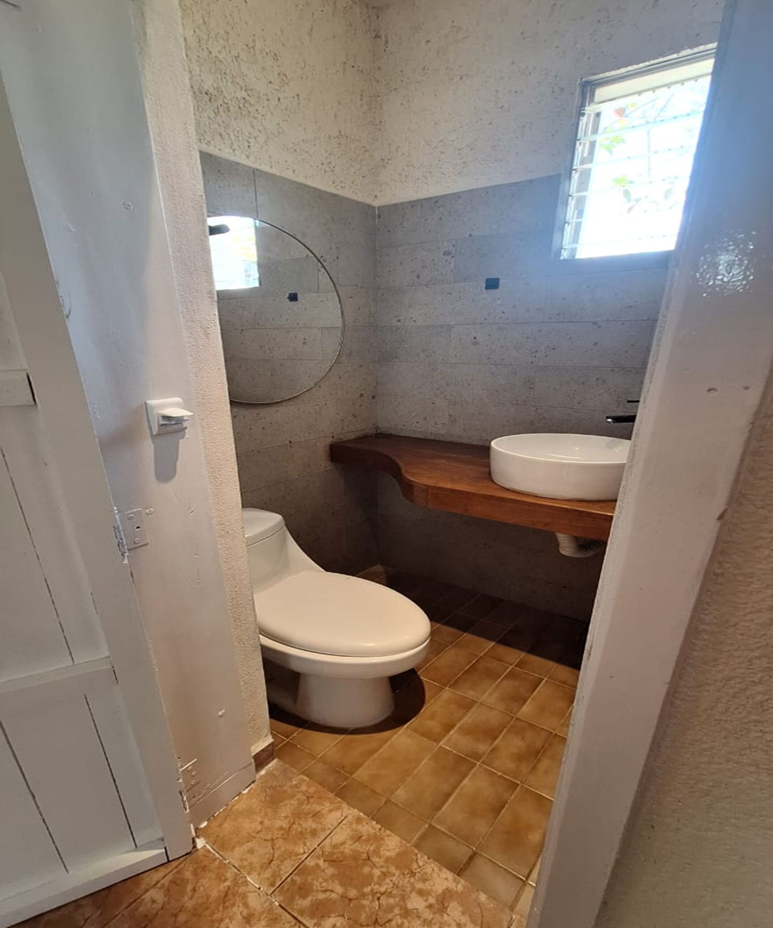 Un bagno piccolo con il water, un lavandino e uno specchio a parete.