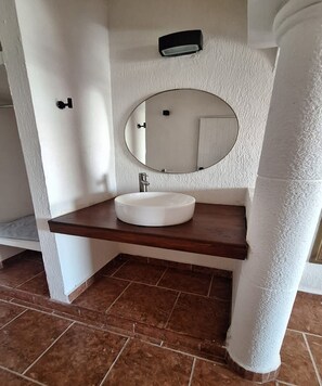A bathroom with a white sink, a round mirror, and a wooden countertop. - Hotel Rolovi Cancun (Cancun)