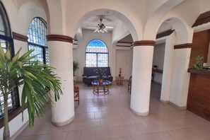 A spacious interior with high ceilings, arched columns, and a central seating area with a sofa and coffee table. - Hotel Rolovi Cancun (Cancun)