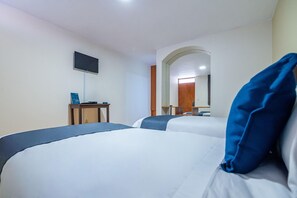 A hotel room with two beds, a desk with a computer, a flat-screen TV, and a mirror. - Hotel Mosna (Arequipa)