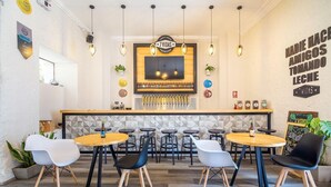 A bar area with a taproom sign, multiple stools, and a counter with taps. - Hotel Mosna (Arequipa)
