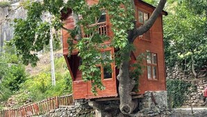 A wooden cabin with a stone foundation, situated by a flowing river. - Kapuzbaşı Baştürk Tesisi (Yahyali)
