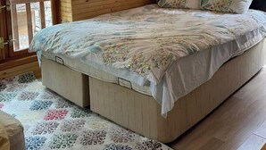 A wooden cabin bedroom with a bed, a window, and a door. - Kapuzbaşı Baştürk Tesisi (Yahyali)
