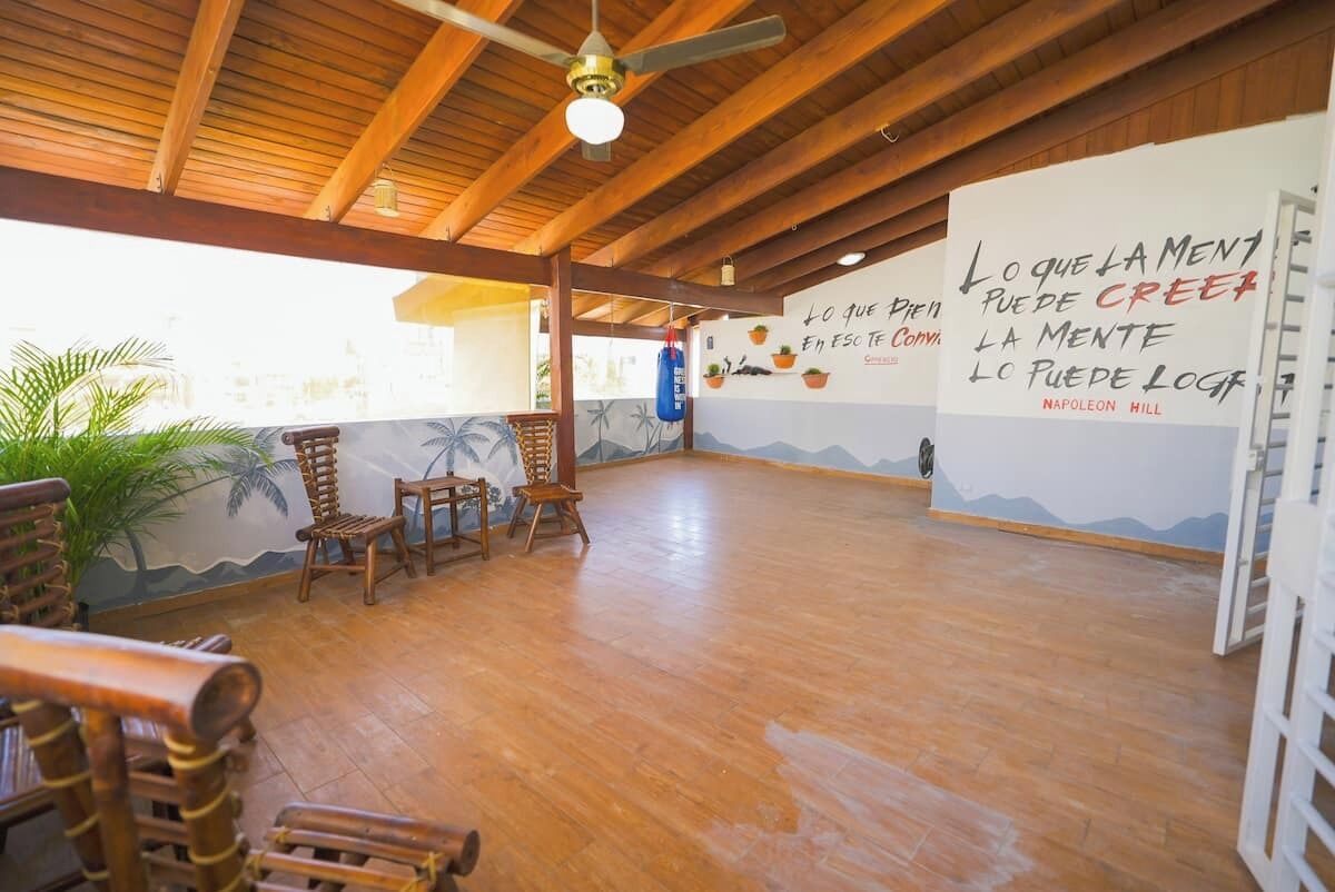 A spacious room with wooden flooring, a ceiling fan, and a mural on the wall.