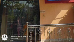 A multi-story building with a signboard indicating availability of a hall and room. - Hotel Natraj (Omkareshwar)
