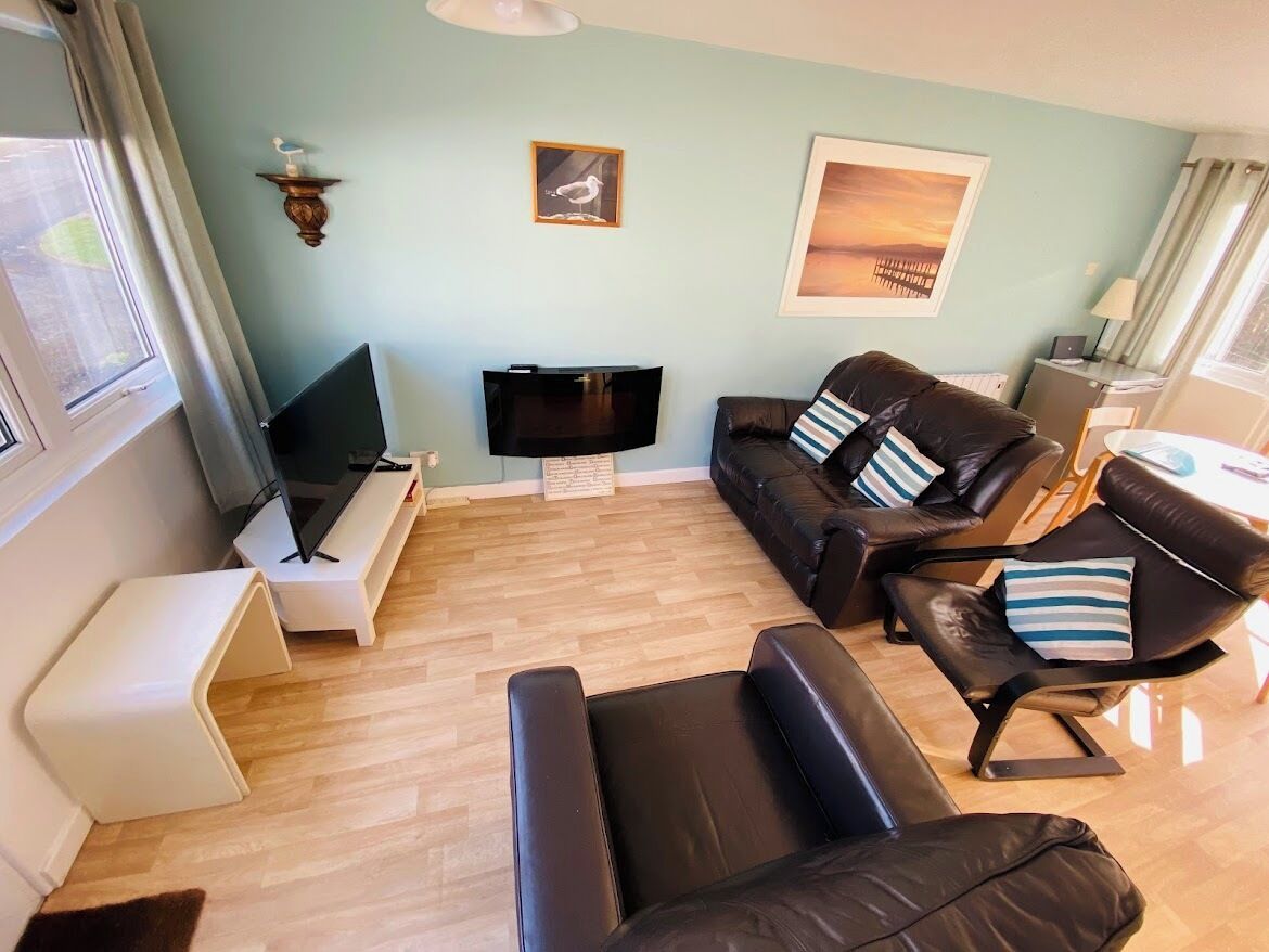 A living room with a sofa, a TV, and a small table.