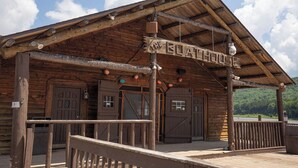 A rustic wooden building labeled "The Boat House" with a wooden deck and a covered entrance.