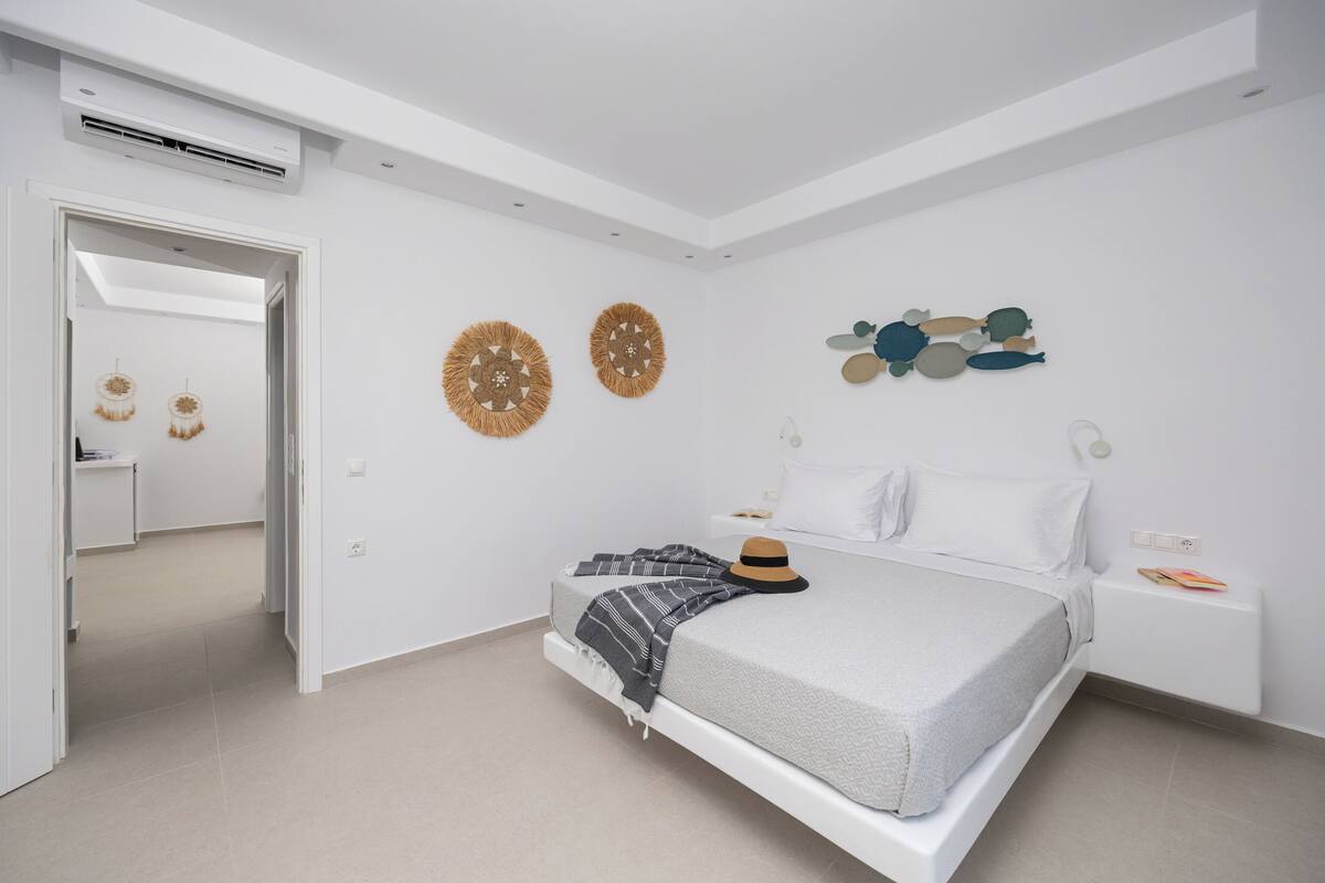 Un dormitorio moderno con cama, mesitas de noche y decoración mural.