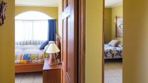 A bedroom with a bed, a nightstand, a lamp, and a window with curtains. - 2-bedroom apartment in charming Cuidad Colon with WiFi. (Cuidad Colon)